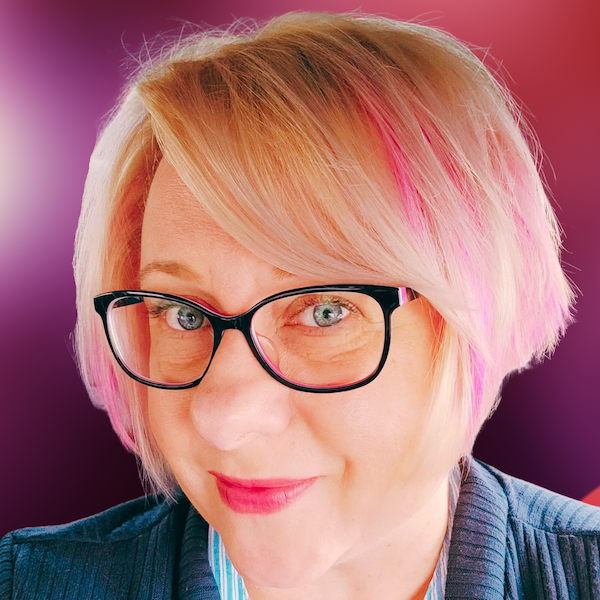 Asa Maria Bradley: a blue-eyed, blonde woman, with pink streaks in her hair, which is cut in a bob. She's smiling and wearing glasses.